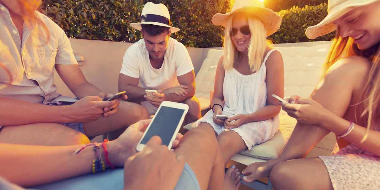 Group of friends using mobile phones.